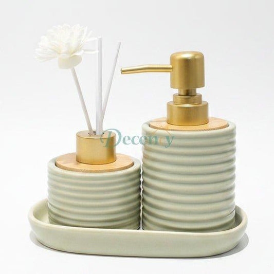 White ribbed ceramic soap dispenser and reed diffuser with flower sticks sitting on a ceramic tray.
