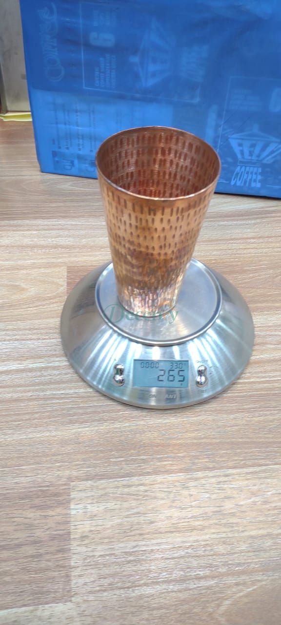 Copper cup on a digital scale with a blue box in the background