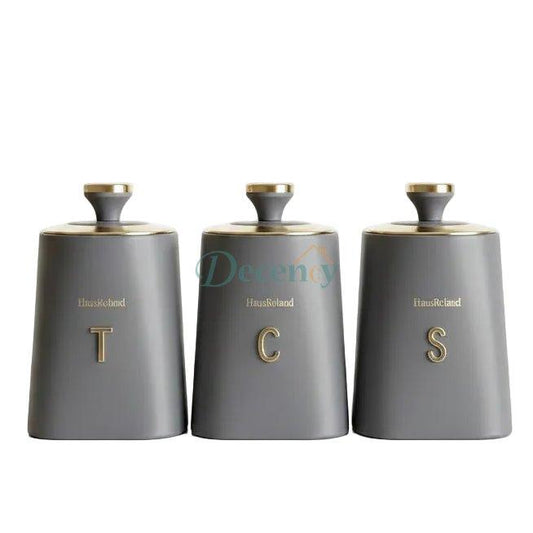 Haus Roland grey ceramic style canister set featuring elegant gold caps and gold T C S letters