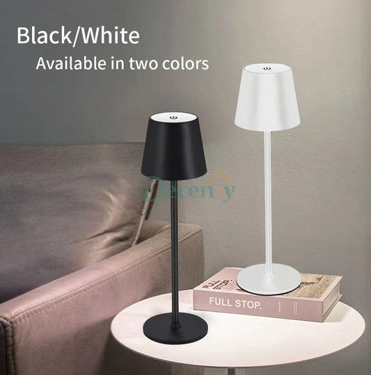 Two table lamps, one black and one white, on a table with a couch in the background.