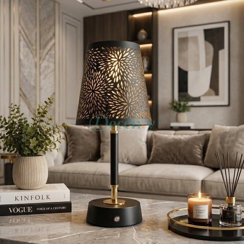 Luna floral cutwork LED table lamp in black and gold placed on a marble coffee table