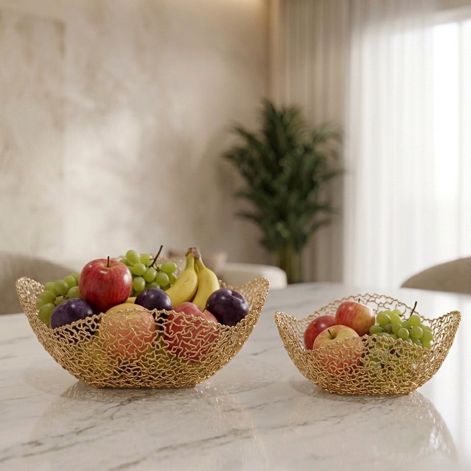 Set of 2 luxury gold mesh decorative fruit bowls placed on a white marble table top.