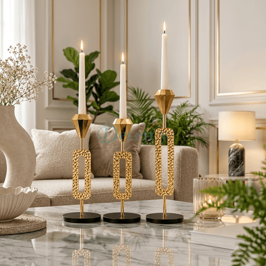 Three premium gold metal candle holders of varying heights displayed on a modern wooden coffee table.