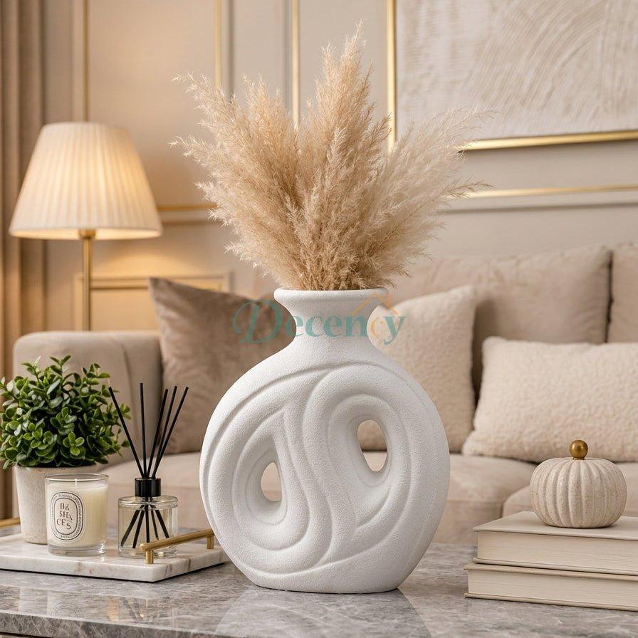 Modern white ceramic donut vase with dried pampas grass on a marble coffee table