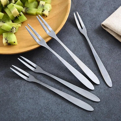 12 pieces stainless steel fruit forks set displayed on dark countertop near kiwi platter