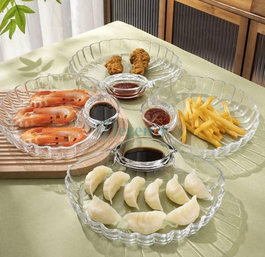2-piece set of clear glass shell-shaped serving plates displayed on a dining table with snacks
