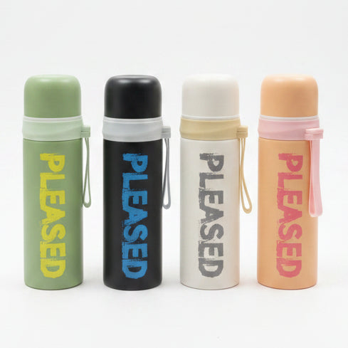 Pleased 500ml insulated water bottles in four matte colors displayed on a luxury table setup