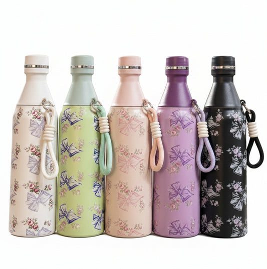 Lineup of five 500ml floral stainless steel water bottles in white, green, pink, purple, and black on a kitchen counter