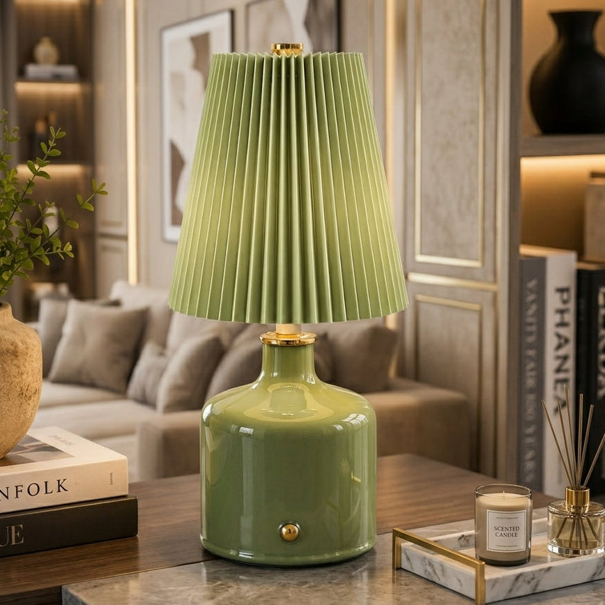 Olive green Aurora ceramic table lamp with pleated shade on a wooden table