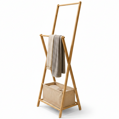 Foldable bamboo clothes rack standing in a modern Pakistani bedroom with hung clothes.