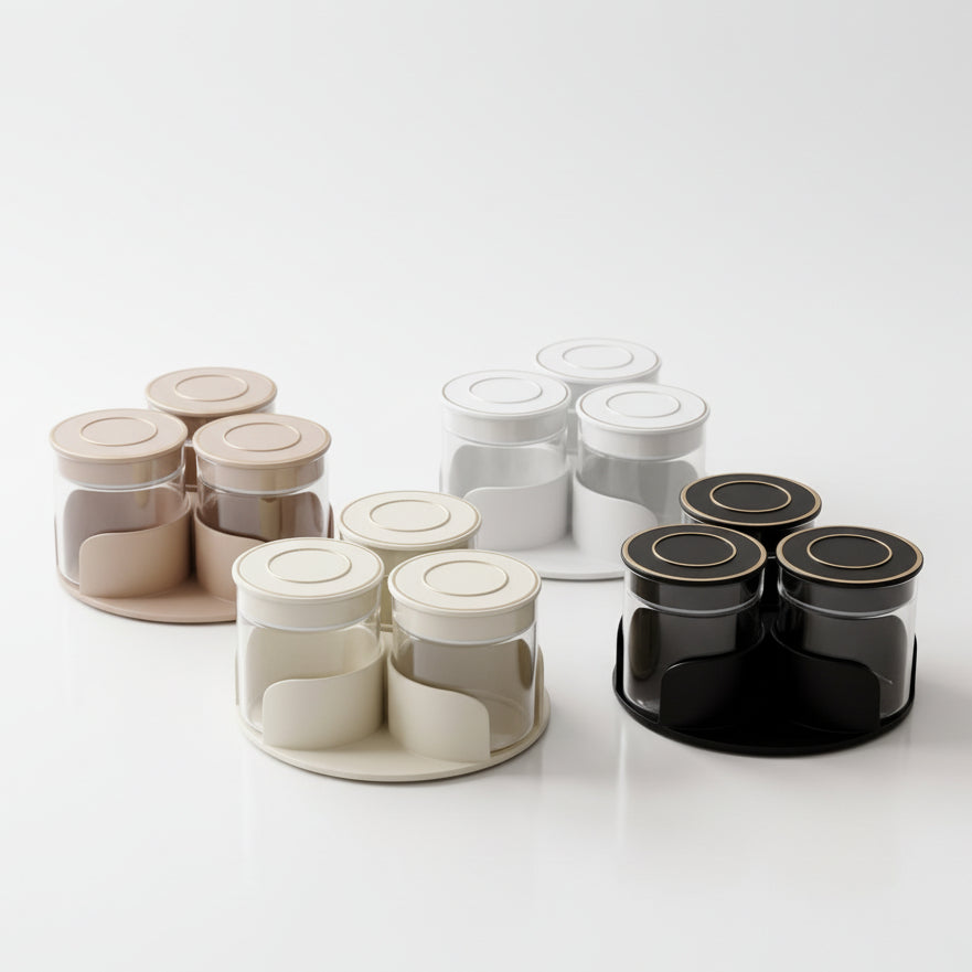 Beige 4-piece rotating spice jar set with clear glass canisters on a kitchen counter.