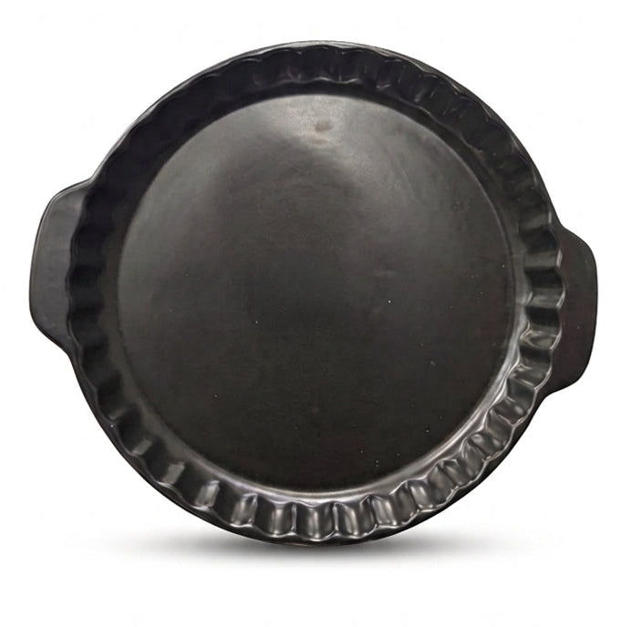 Top view of a matte black round ceramic tart mold with side handles.
