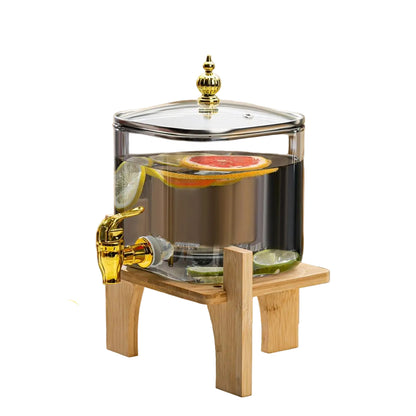 Modern glossy black glass beverage dispenser with a gold tap and wooden stand on a tabletop.