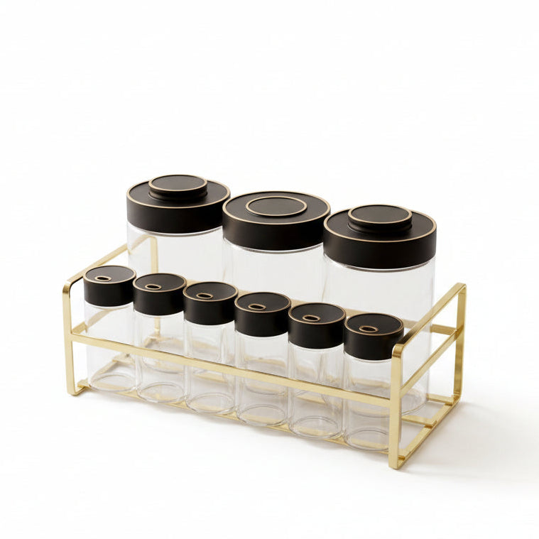 9-piece clear glass spice jar set with black lids on a metallic gold rack