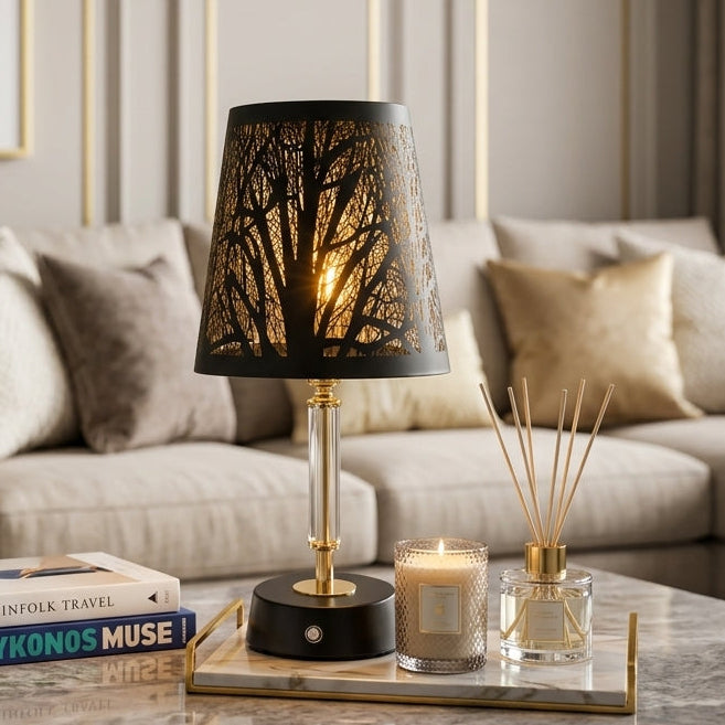 Modern black and gold cutout table lamp glowing on a marble coffee table in a modern living room