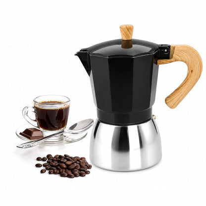 Black Italian Moka Pot espresso maker with wooden handle placed next to roasted coffee beans and a fresh espresso cup.