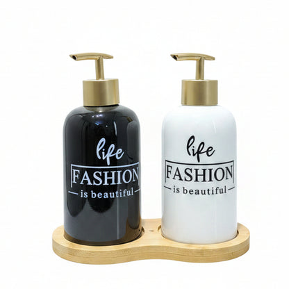 Black and white ceramic liquid soap dispenser set with gold pumps on a bamboo tray