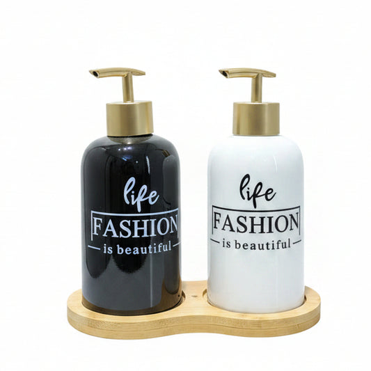 Black and white ceramic liquid soap dispenser set with gold pumps on a bamboo tray