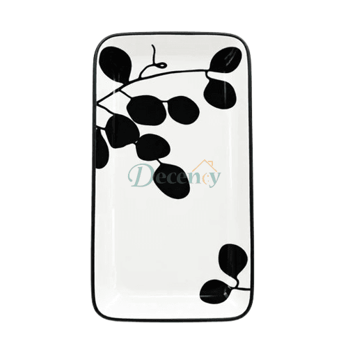 Top-down view of a rectangular ceramic serving tray featuring a black leaf and branch pattern on a white background.   
