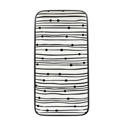 Top view of a rectangular black and white striped ceramic serving platter with graphic dot patterns against a white background
