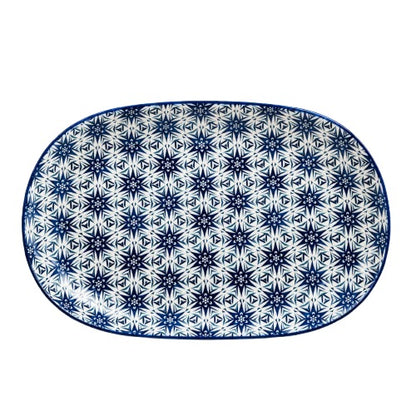 Top-down view of an oval blue starburst geometric ceramic serving platter against a clean white background.