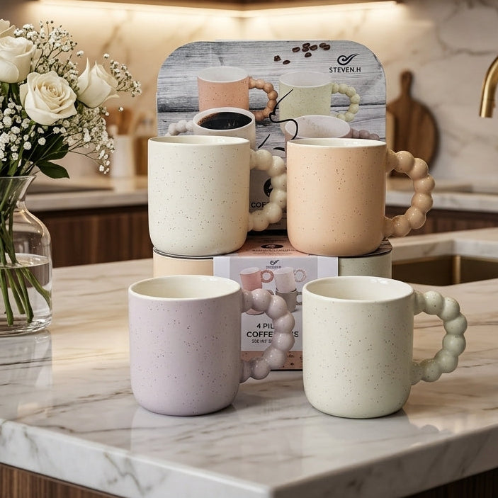 Set of 4 aesthetic ceramic mugs with bubble handles in pastel shades on a marble kitchen counter
