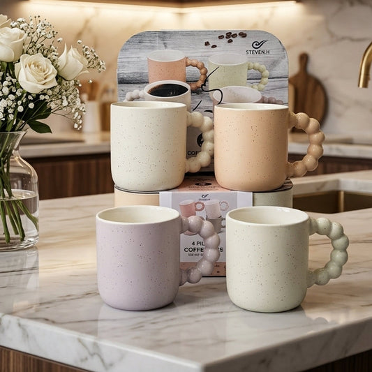Set of 4 aesthetic ceramic mugs with bubble handles in pastel shades on a marble kitchen counter