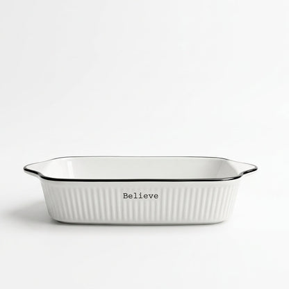 White ceramic porcelain baking dish with black rim on a kitchen counter