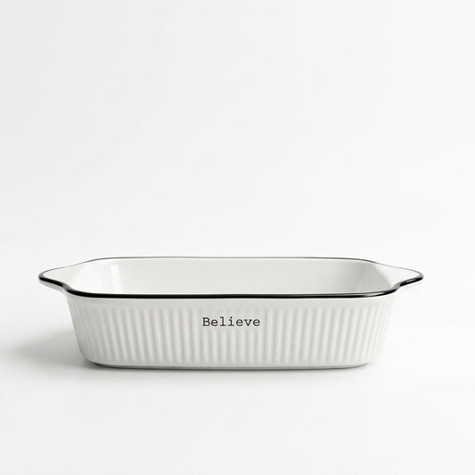 White ceramic porcelain baking dish with black rim on a kitchen counter