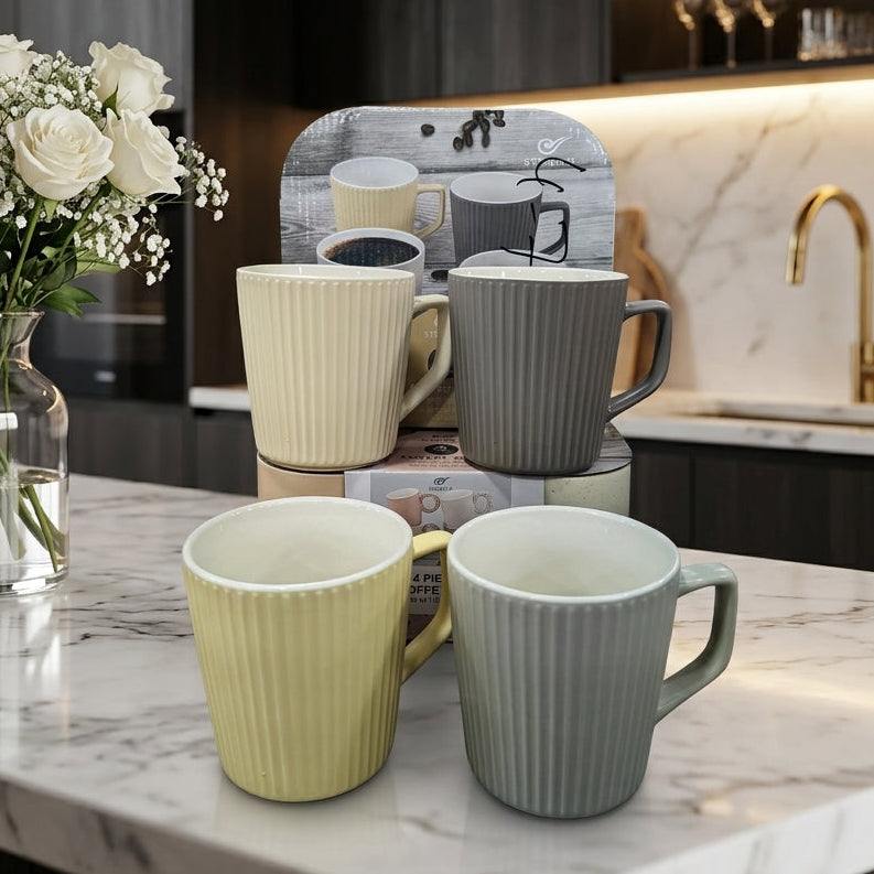 Four piece ribbed ceramic coffee mug set displayed on a kitchen marble countertop