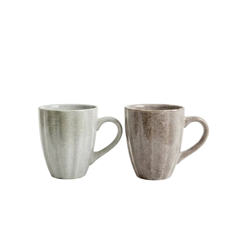 Pair of green and brown ribbed ceramic coffee mugs placed on a white marble countertop