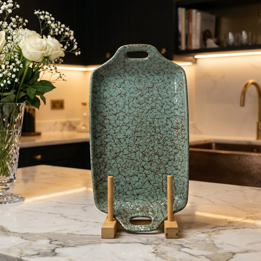 Turquoise crackle glazed ceramic serving tray standing upright on a wooden display holder.