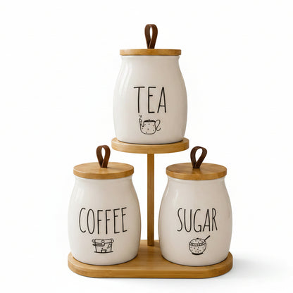 3-piece white ceramic tea, coffee, and sugar jar set on a 2-tier wooden stand on a marble countertop