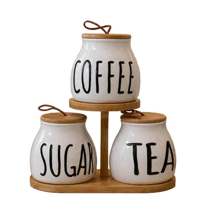 3 piece white ceramic tea sugar coffee jar set arranged on a two tier wooden stand