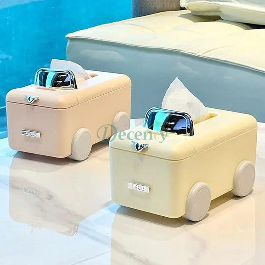 Pair of cute pastel car-shaped tissue box dispensers in cream and soft pink on a table.