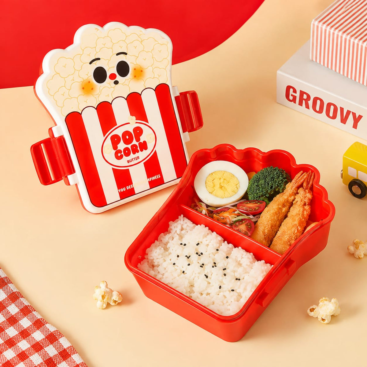 Open red popcorn design kids lunch box showing rice and snack compartments