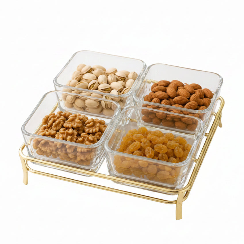 Danny Home 4-section square clear glass snack bowl set resting on a stylish gold metal stand filled with assorted dry fruits.