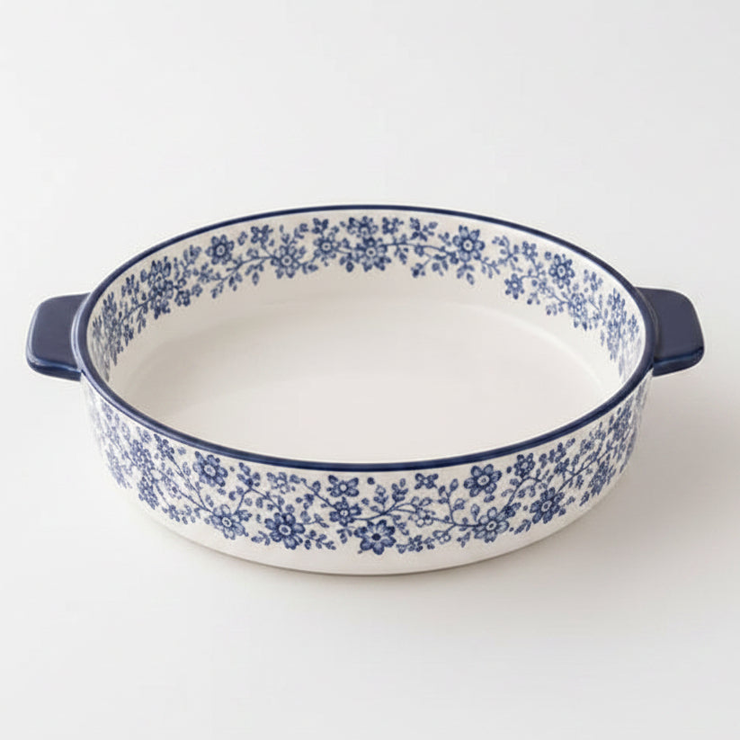 Danny Home 8 inch round porcelain baking dish with blue floral pattern placed on a marble kitchen counter