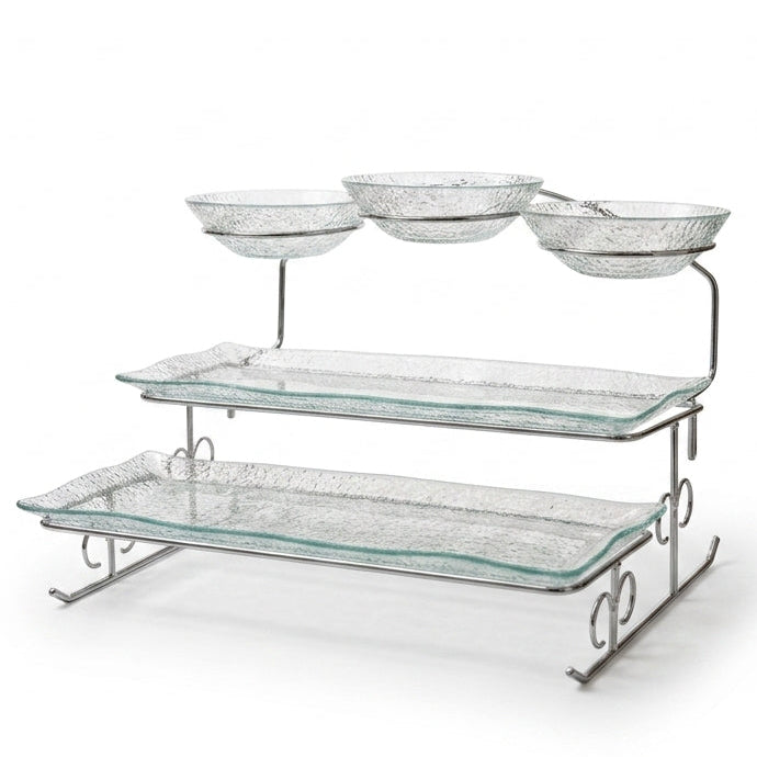 Danny Home multi-tiered clear glass serving tray and bowl stand set on a marble kitchen island.
