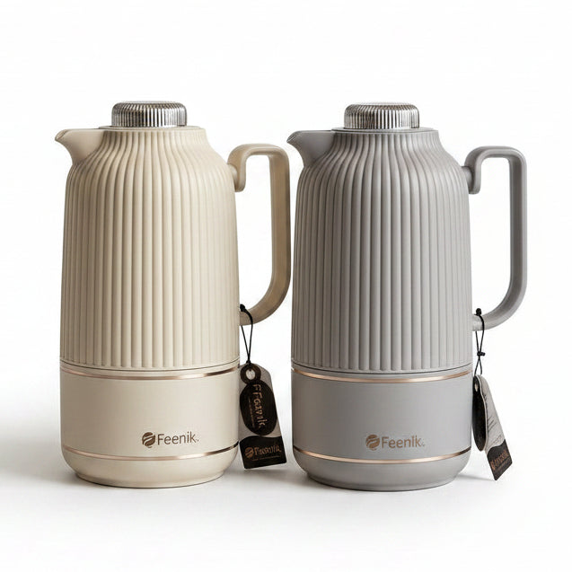 Two 1 litre Day Days ribbed vacuum flasks in beige and grey displayed on a marble kitchen counter next to white roses.