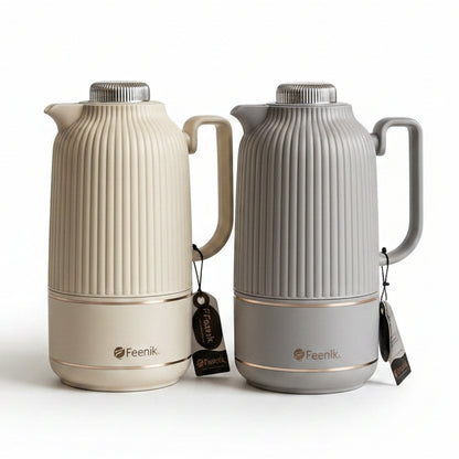 Two 1 litre Day Days ribbed vacuum flasks in beige and grey displayed on a marble kitchen counter next to white roses.