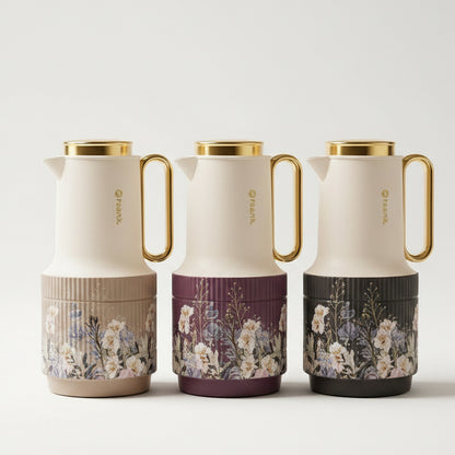 Three luxury Feenik 1 Litre vacuum flasks in beige, purple, and black with floral bases on a marble kitchen counter.