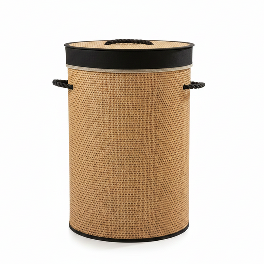 Handwoven round bamboo laundry basket with lid placed in a modern bedroom setting