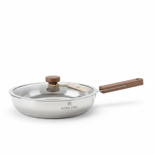 HOMLAND 24cm 304 stainless steel frying pan with glass lid on a white marble kitchen countertop.