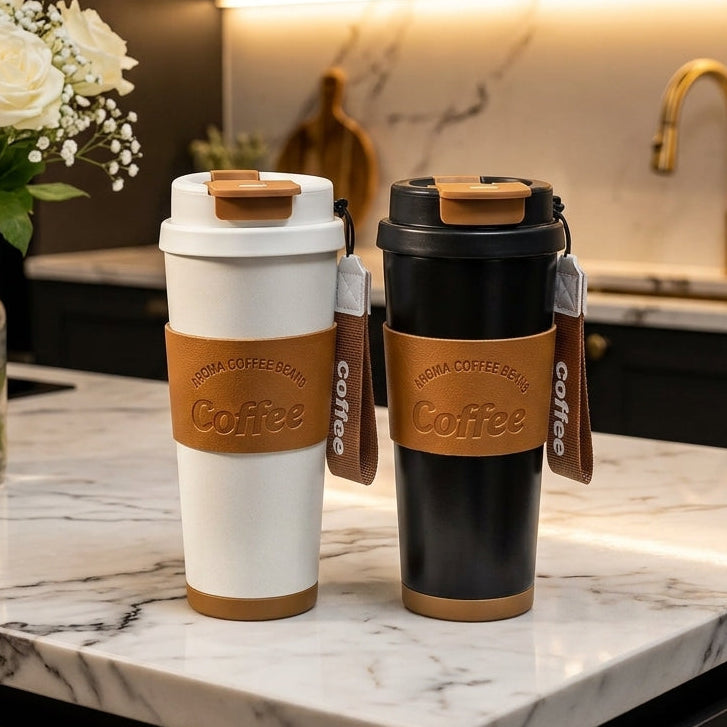 White and black insulated coffee travel mugs with leatherette sleeves and wrist straps on a kitchen counter