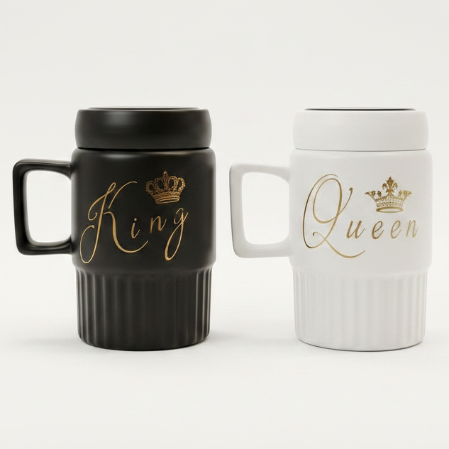 Black King and white Queen ceramic coffee mug set with gold calligraphy placed on a modern marble kitchen counter.