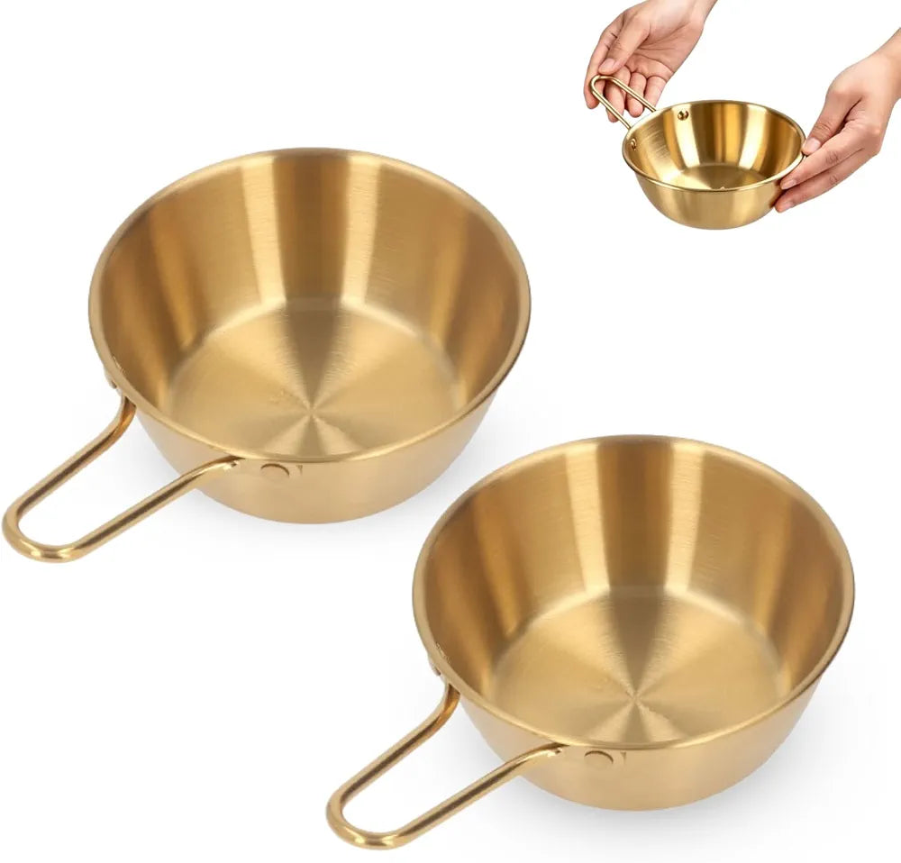 Korean stainless steel gold bowls filled with soup, rice, and ramen dishes on a table