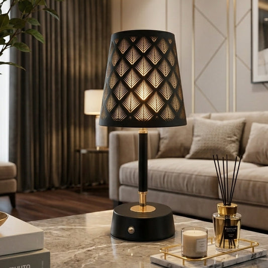 Black and gold metal table lamp with geometric leaf cutout shade on marble table