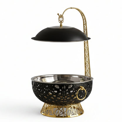 Black and gold luxury 8L food warmer chafing dish placed on a marble kitchen countertop.
