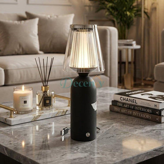 Modern black cordless table lamp with a fluted crystal shade placed on a marble coffee table in a modern living room.